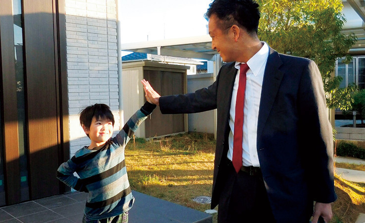加納さんと子どもが玄関前でハイタッチをしている様子