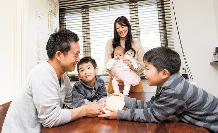 家の中で話し合う加納さん家族の写真