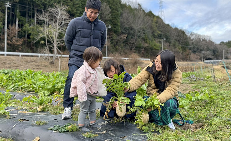 野菜を収穫している寺西さん一家の写真