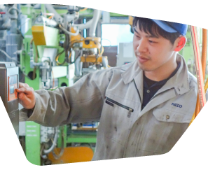 工場で働いている男性が機械のスイッチを押している写真